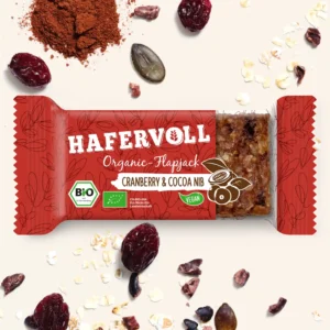 HAFERVOLL Organic Flapjack Cranberry & Cocoa Nib 60g – Riegel in der Verpackung mit Cranberrys und Kakaonibs